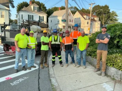 Deroma Construction Team posing for a photo on the street.