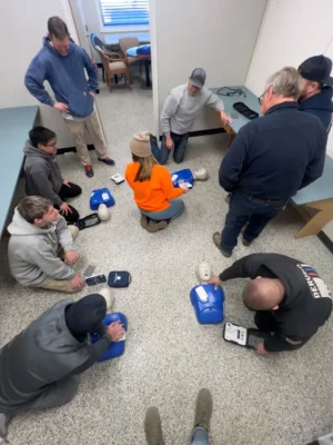 Deroma Construction Team practicing CPR during a safety training session.