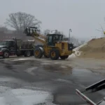 Deroma truck and loader working during snowy weather