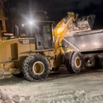 Deroma CAT loader working in snow during night shift